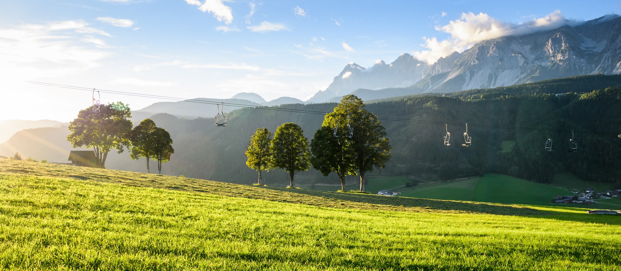 Sessellift im Sommer - im Hintergrund das Dachsteingebirge in der Steiermark, Österreich