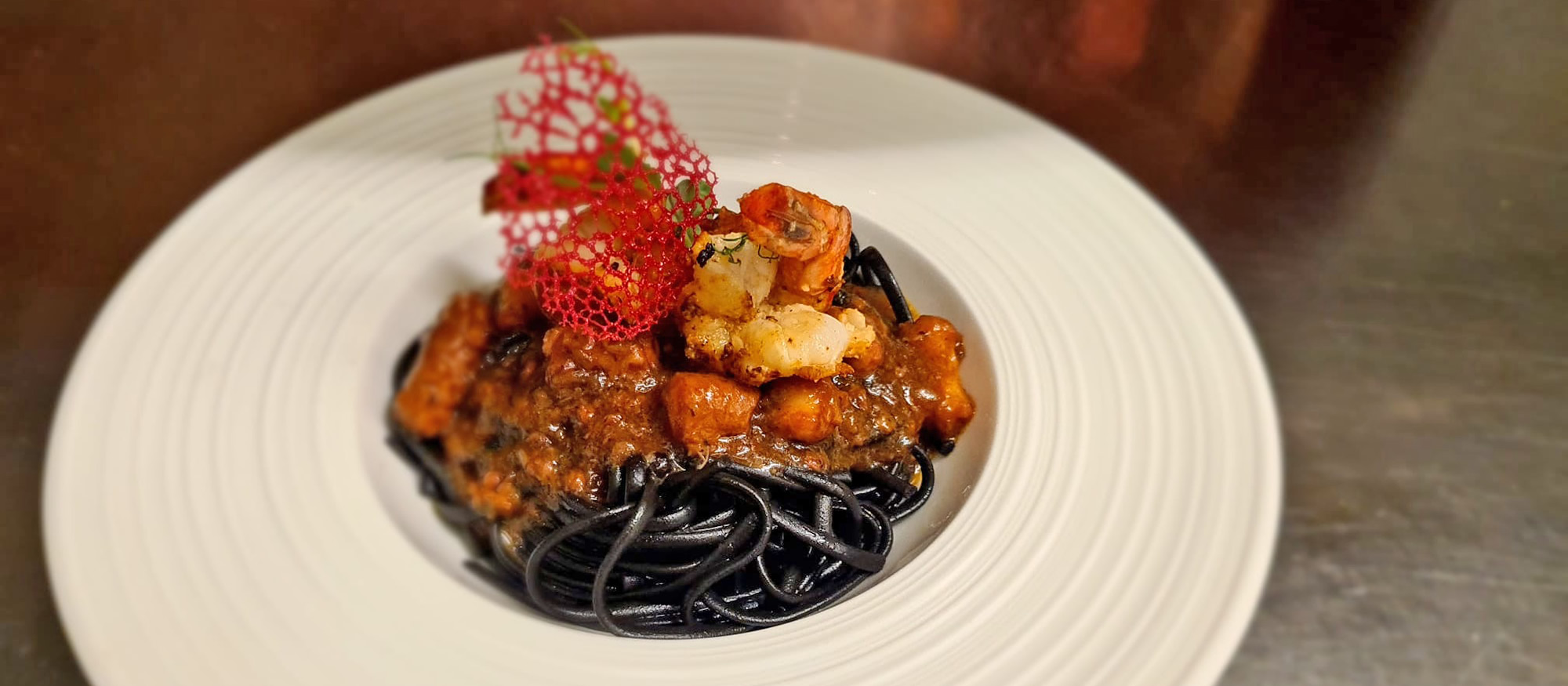 Regionale und internationale Köstlichkeiten wie Sepia Spaghetti im Restaurant Pariente in Rohrmoos bei Schladming